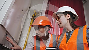 Two women checker checking technical data of heating system equipment in a boiler room