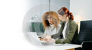 Two women coding together in a high-tech office, showcasing teamwork, software development, and female empowerment