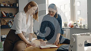 Two women collaborating in a home sewing workshop