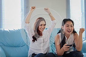 Two women Competitive friends playing video games and excited ha