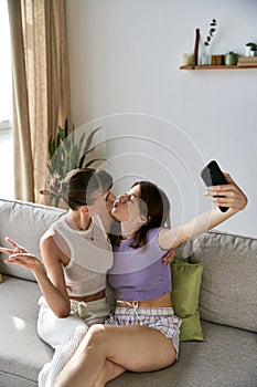 Two women on a couch, capturing photo