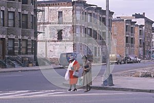 Two women crossing street in ghetto, South Bronx, New York