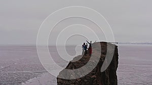 Two women dancing on top of a mountain.