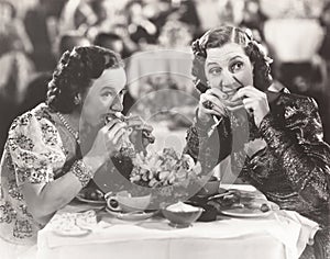 Two women distracted from their meal