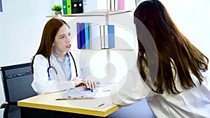 Two women doctors consultation with professional specialist diagnostics at hospital medicare treatment clinic. Doctor writing pres