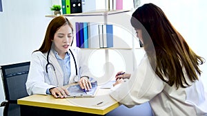 Two women doctors consultation with professional specialist diagnostics at hospital medicare treatment clinic. Doctor writing pres