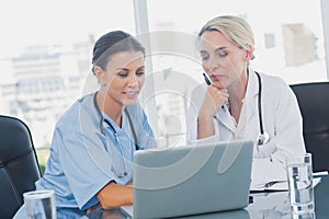 Two women doctors working on a laptop