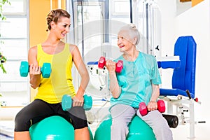 Two women doing strength sport in fitness gym