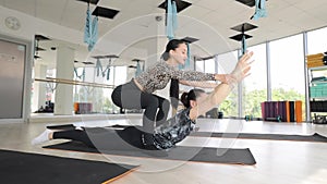 Two women doing yoga in active pants on wooden flooring