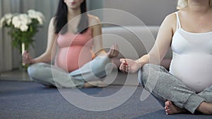 Two women doing yoga exercises for pregnant to relax and calm down at home