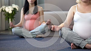 Two women doing yoga exercises for pregnant to relax and calm down at home