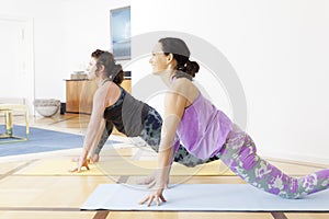 Two women doing yoga at home