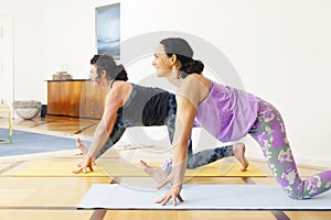 Two women doing yoga at home