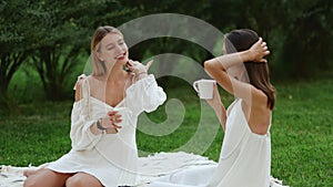 Two women drink relaxing tea after meditation and yoga.