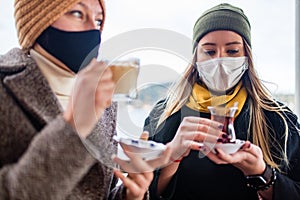 two women drinking turkish tea and salep while wearing medical mask coronavirus time
