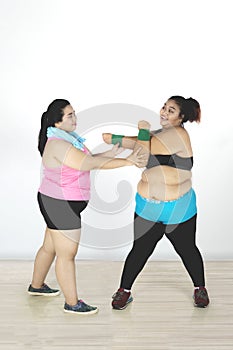 Two women exercising together in the gym