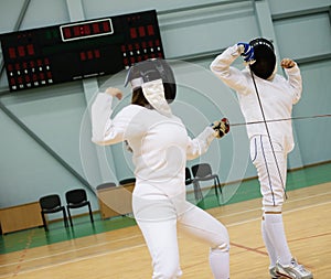 Two women on a fencing training