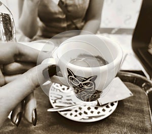 Two women friends drinking dark brown coffee indoors shop cafe