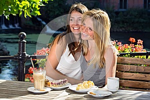 Two women friends hugging and laughing