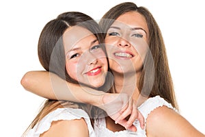 Two women friends laughing with a perfect white teeth with a green background