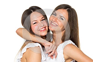 Two women friends laughing with a perfect white teeth with a green background