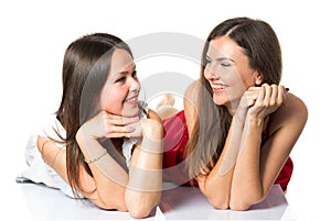 Two women friends laughing with a perfect white teeth with a green background