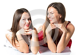 Two women friends laughing with a perfect white teeth with a green background