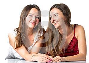 Two women friends laughing with a perfect white teeth with a green background