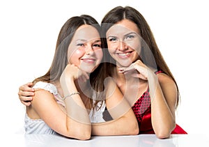 Two women friends laughing with a perfect white teeth with a green background