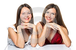 Two women friends laughing with a perfect white teeth with a green background