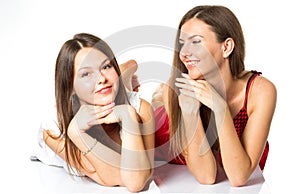 Two women friends laughing with a perfect white teeth with a green background