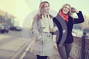 Two women friends traveling in city