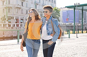 Two women friends walking on street