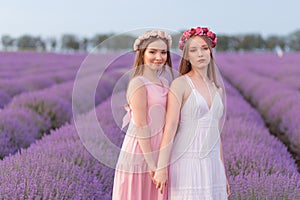 Two women girlfriends posing in lavender field enjoying field view
