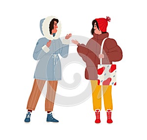 Two women or girls in modern winter outfits greet each other and have a conversation. Meeting of two old girlfriends in