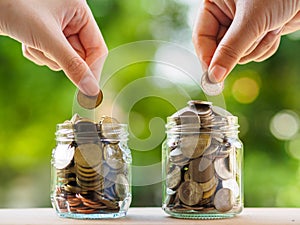 Two women hand putting money coin into glass jar for saving money. saving money and financial concept