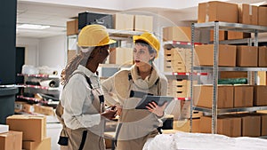 Two women with hardhats organizing products