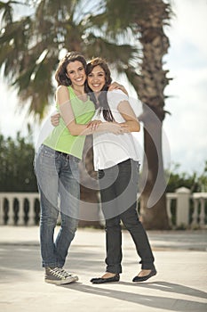 Two women having fun under palm trees