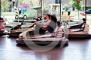 Two women having a lot of fun in the amusement park, driving bumper cars