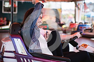 Two women having a lot of fun in the amusement park, driving bumper cars