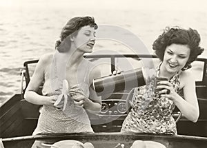 Two women having a snack on motorboat