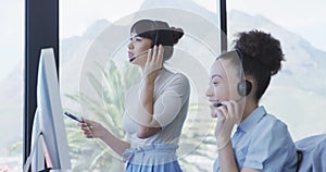 Two women with headset working on computer