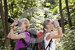 Two women hiking and looking with binoculars