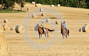 Two Women Horseback Riding in a Field