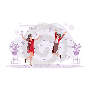 Two women are jumping and celebrating happiness by throwing confetti.
