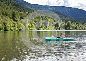 Two women Kayaking on a pristine mountain lake in the state of Washington Pacific Northwest.