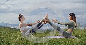Two women keeping balance and meditating outdoors
