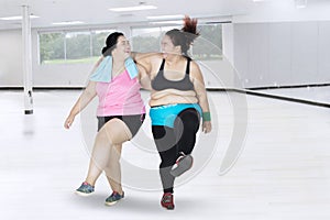 Two women laughing in the fitness center