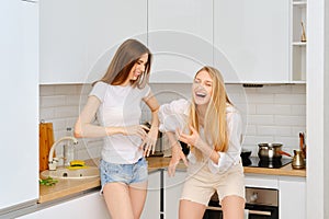 Two women laughing in the kitchen