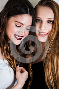 Two women laughing on a white background. Positive emotions, expressive facial features, joy, happiness, friendship concept